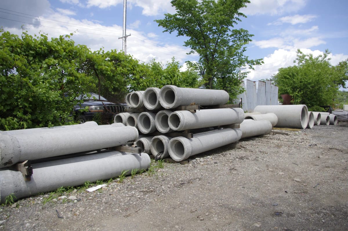 Concrete drainage pipe stored in an outdoor yard