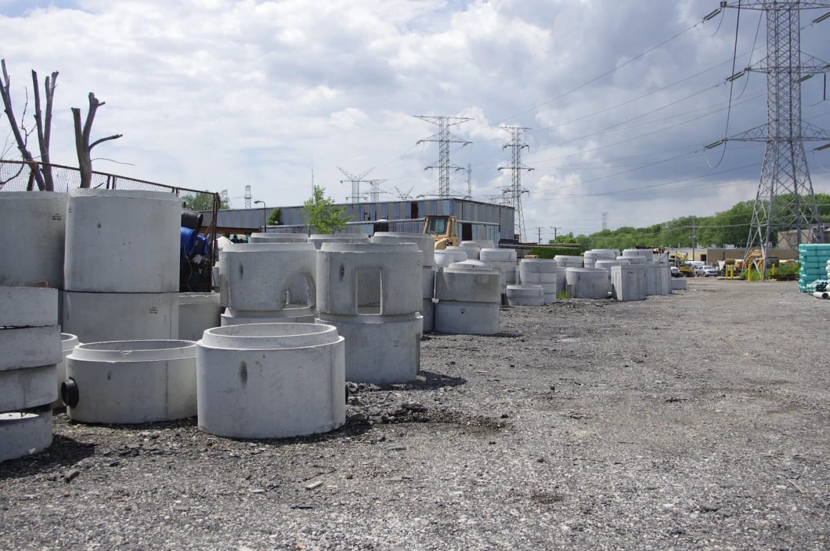 Precast concrete manhole sections stacked in a yard